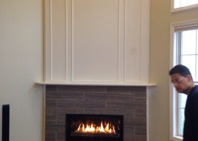 electric fireplace with dark stone tile surround and light white painted wood surround and mantel