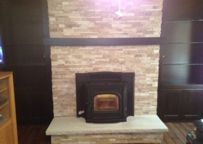 fireplace insert with light stone surround and floating dark wood mantel
