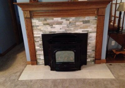 fireplace insert with custom stone surround and wooden mantel