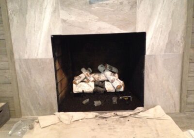 light birchwood gas log set in gas fireplace with custom light stone surround