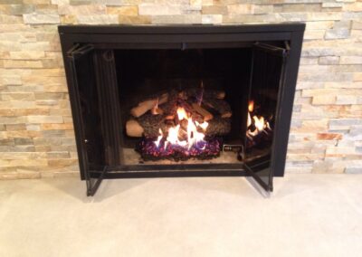 gas fireplace with custom light stone surround