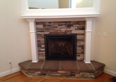 gas fireplace with custom surround and mantel in corner of room