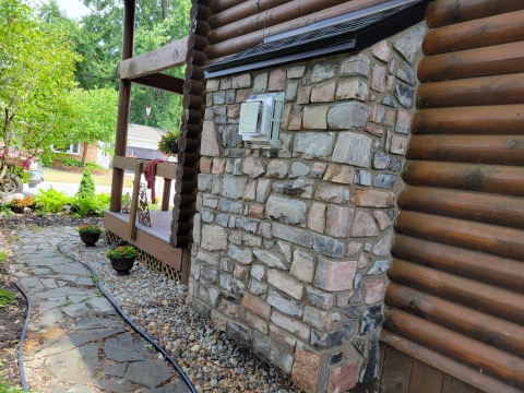 electric fireplace with custom stone surround and venting system outside of a cabin