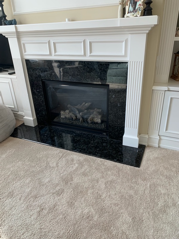 gas fireplace with white mantel and marble surround