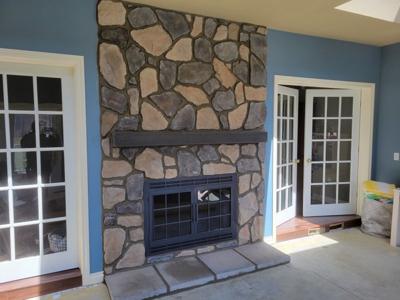 Outdoor fireplace with custom stone surround and mantel