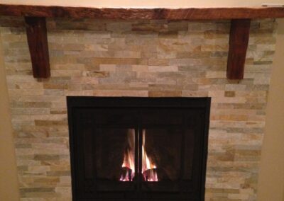 wood-burning fireplace with custom light stone surround and wooden mantel