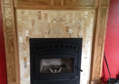 wood-burning fireplace with custom surround and light wood mantel