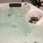 The image shows a bubbling hot tub in our showroom