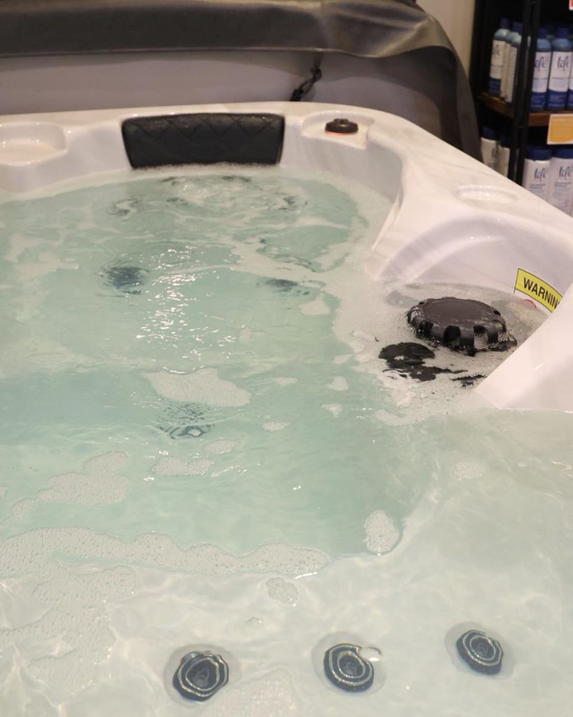 The image shows a bubbling hot tub in our showroom