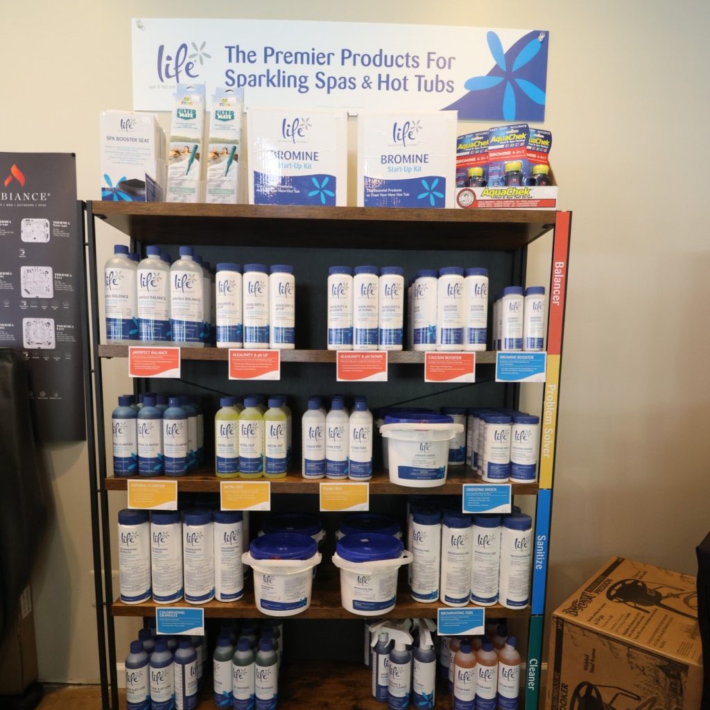 The image shows a shelf featuring some of the products we carry to take care of your hot tub